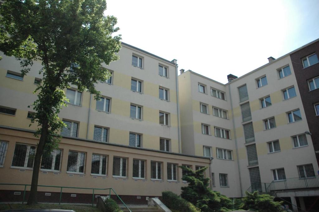 a row of buildings with a tree in the foreground at Klimczoka 6 in Katowice