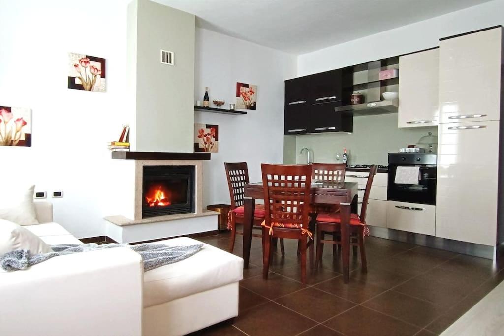 a living room with a table and chairs and a fireplace at Elly's house in Alessandria