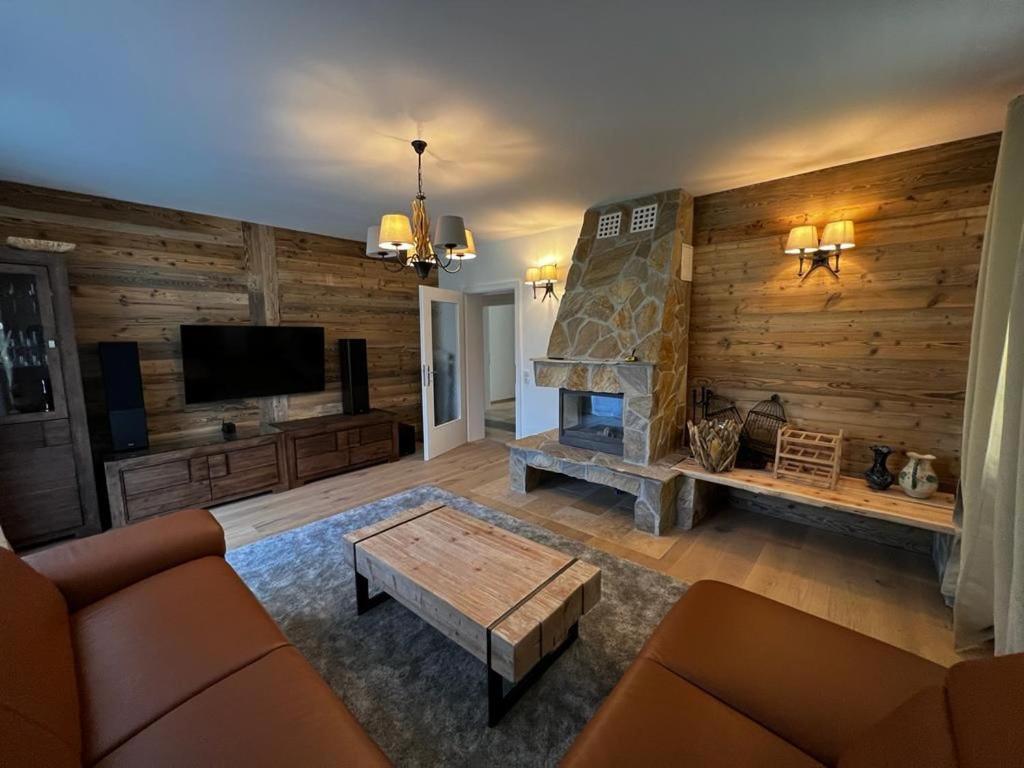 een woonkamer met een bank en een open haard bij WM ENNSTAL in Schladming
