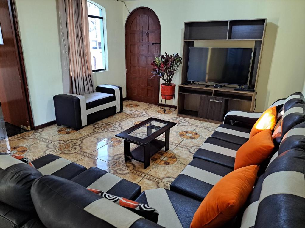 a living room with a couch and a television at Departamento amoblado en Arequipa, Yanahuara in Yanahuara