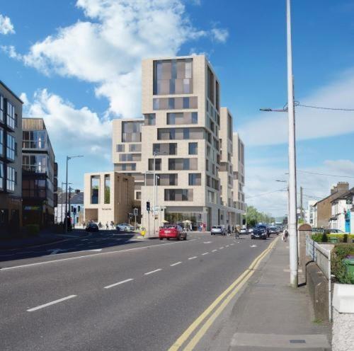 un edificio alto en una calle de la ciudad con coches en The Crows Nest - UCC Summer Beds, en Cork