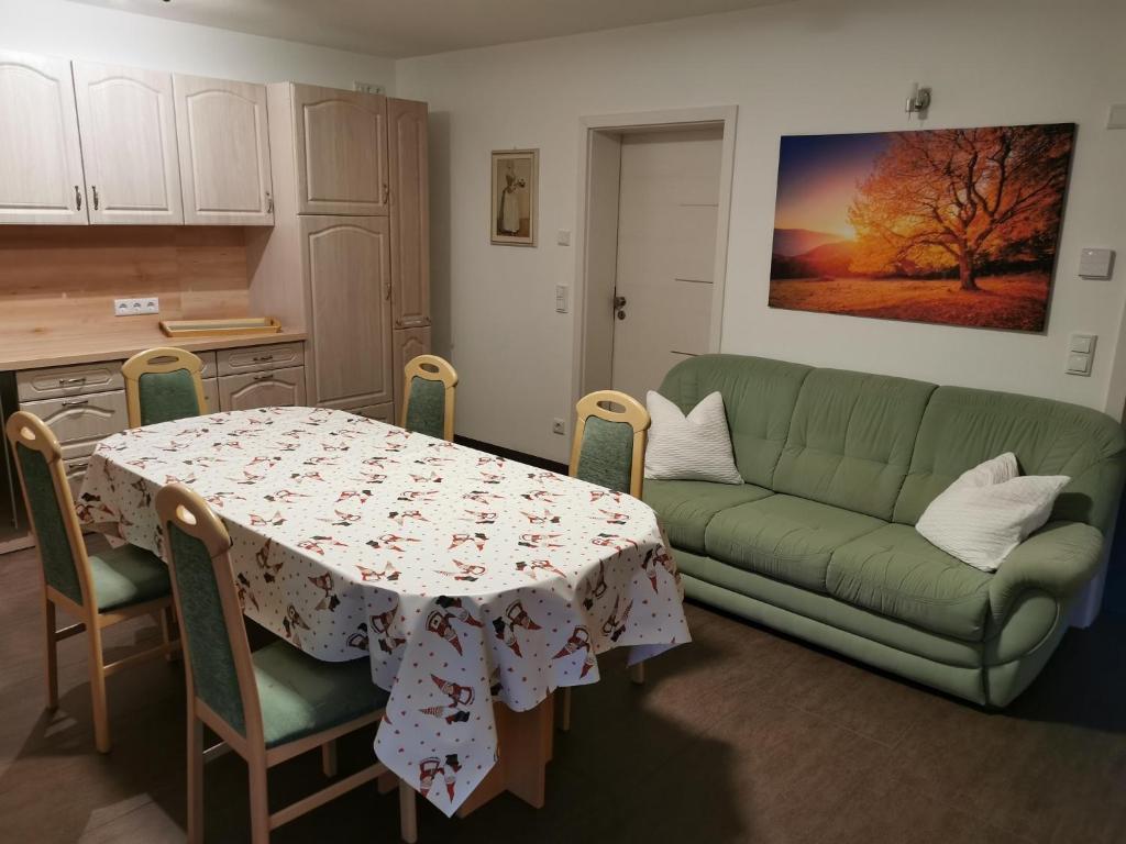 a living room with a table and a green couch at Reichstädter Ferienidyll in Dippoldiswalde