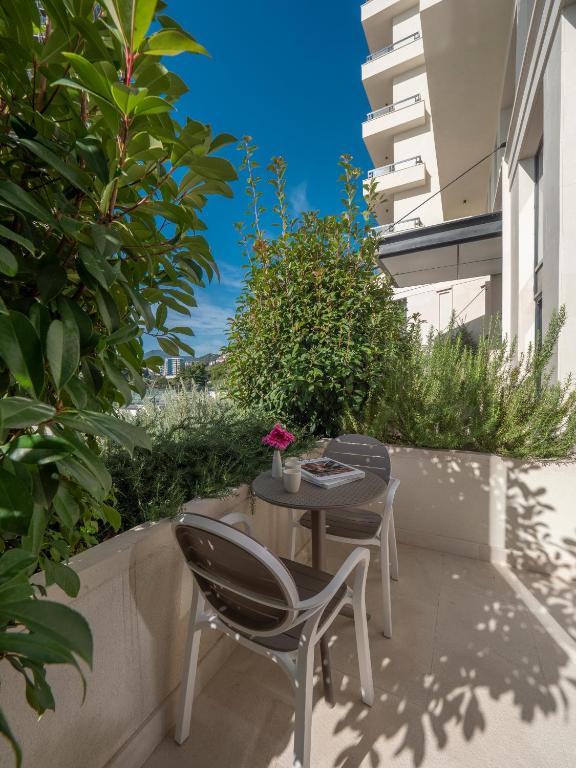 a patio with a table and chairs on a balcony at CASA AL MARE RESIDENCE in Bečići