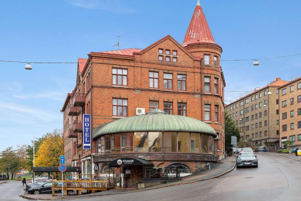 ein großes Backsteingebäude mit einem Uhrturm auf einer Straße in der Unterkunft Best Western Tidbloms Hotel in Göteborg