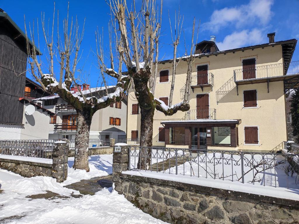 two trees in front of a building in the snow at Appartamento Belvedere Abetone in Abetone