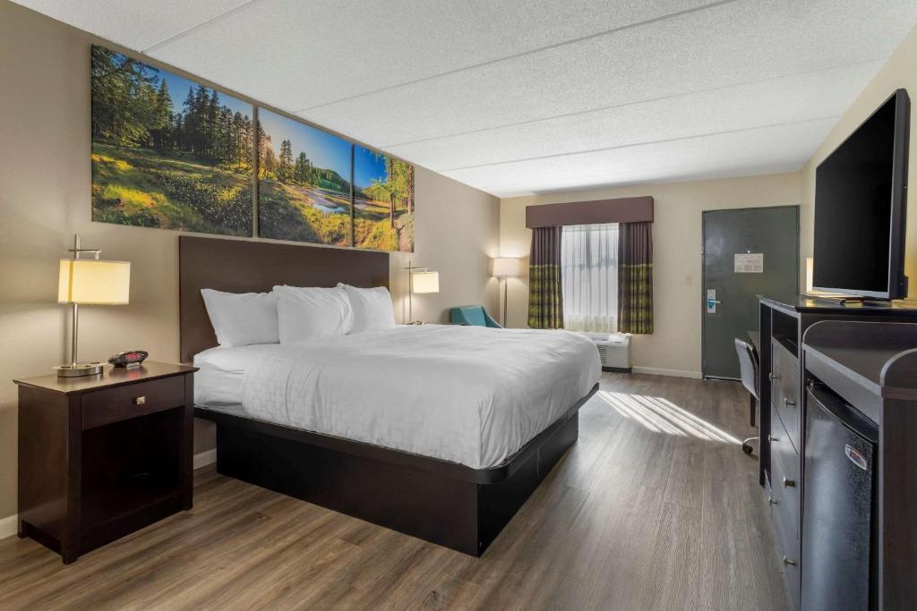 a hotel room with a bed and a flat screen tv at Clarion Pointe Kimball in Kimball
