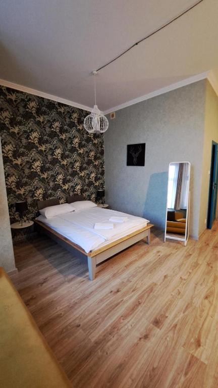1 dormitorio con 1 cama grande y suelo de madera en Villa Grudziądz, en Grudziądz