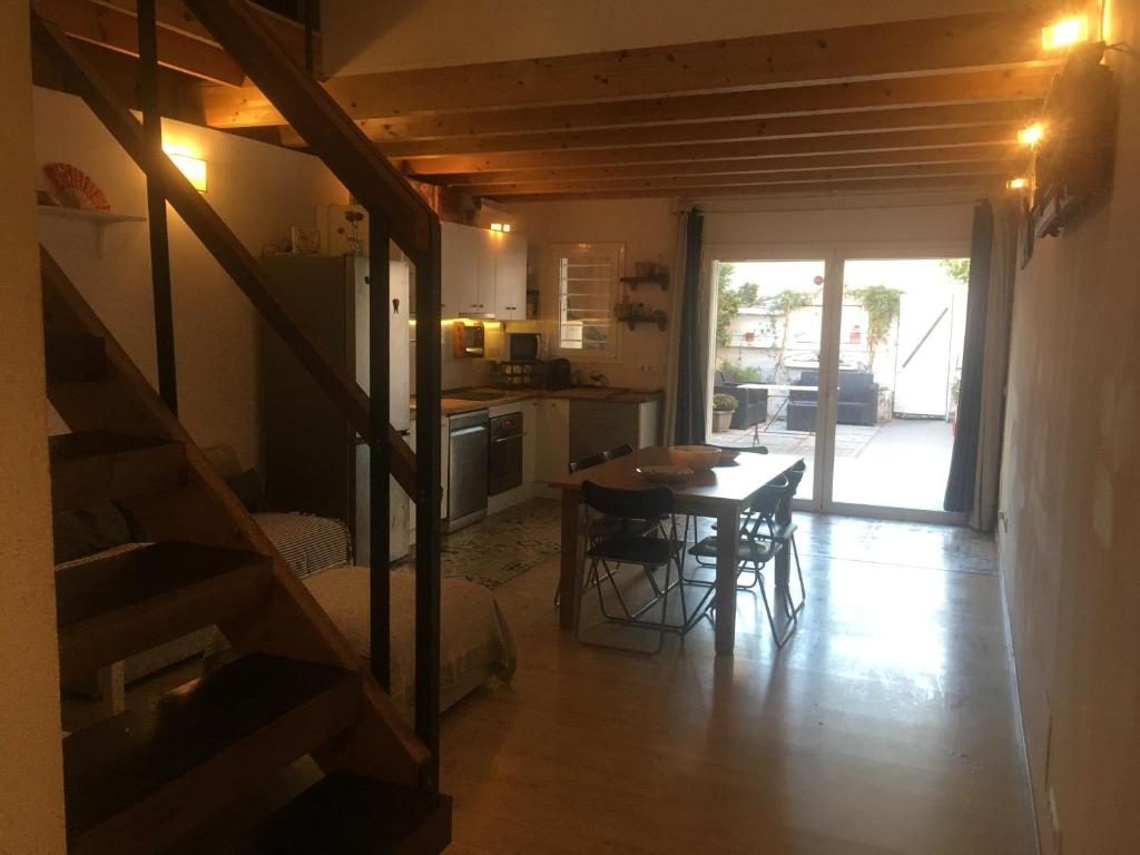 uma cozinha e sala de jantar com uma mesa e uma escada em Charming house next to the sea and Barcelona for 6 em Badalona
