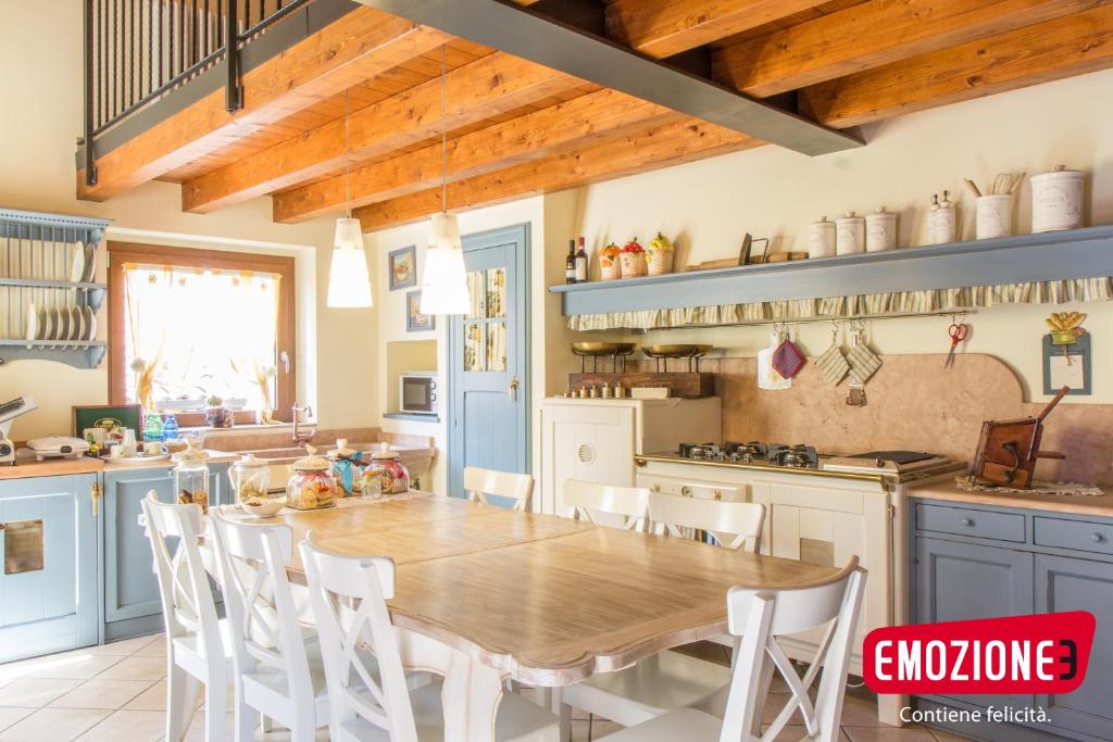 a kitchen with a wooden table and white chairs at B&B I fiori di Marianna in Bergamo