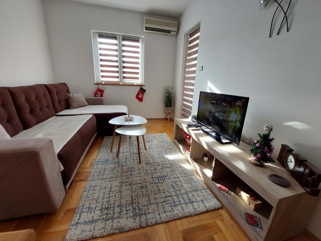 a living room with a couch and a flat screen tv at Apartman Lena in Vrnjačka Banja