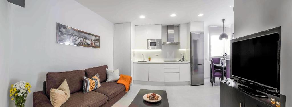 ein Wohnzimmer mit einem Sofa und einer Küche in der Unterkunft Apartamentos Levante in Zahara de los Atunes