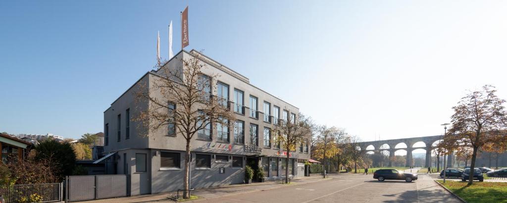 a building on a street with a bridge in the background at Hotel Eberhards am Wasser in Bietigheim-Bissingen