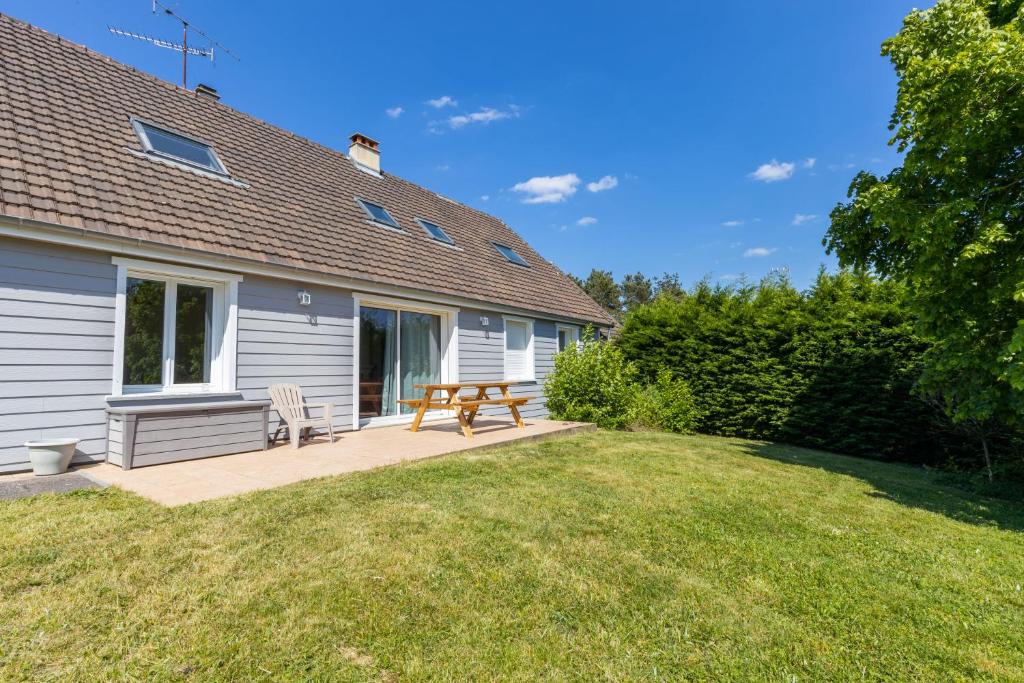 a backyard with a picnic table and a bench at Maison des Grands Champs in Saint-Aignan