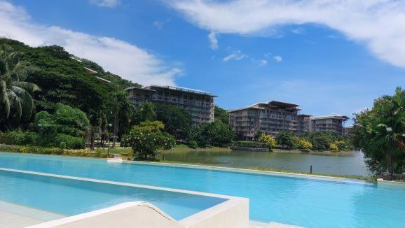 a large swimming pool with buildings in the background at Pico De Loro Condo Unit in Nasugbu