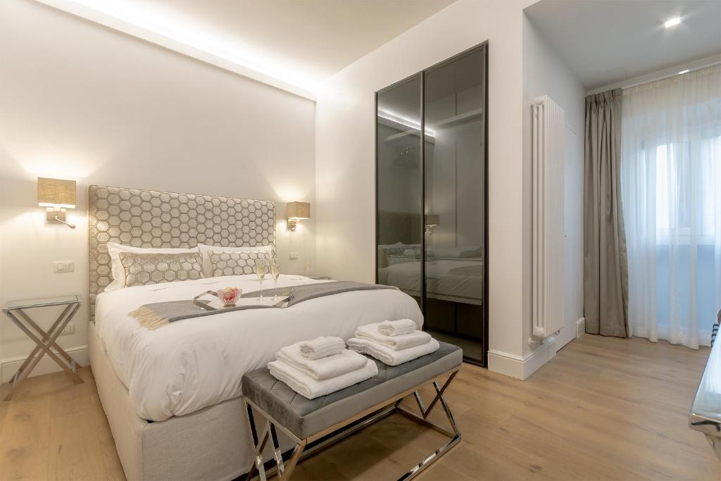 una camera bianca con un grande letto con asciugamani di Diva Lodging Luxury - Signoria a Firenze