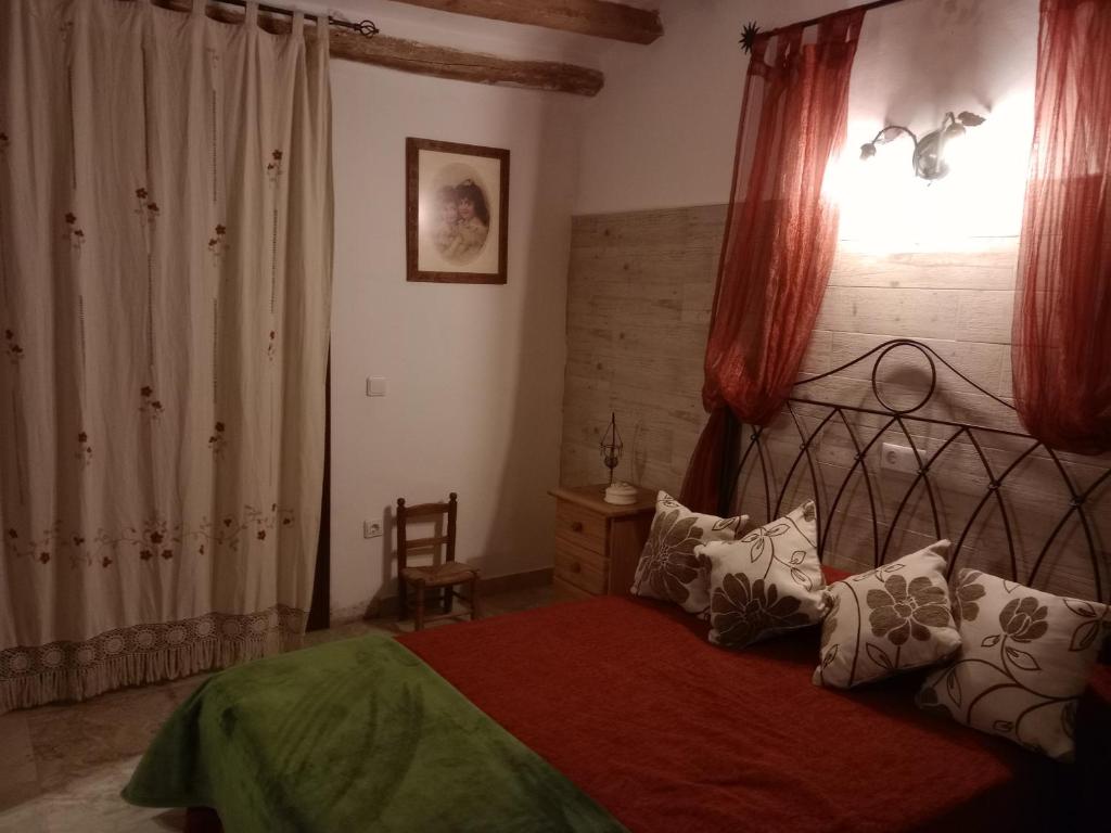 ein Schlafzimmer mit einem Bett mit einer roten Decke und einem Fenster in der Unterkunft CASA RURAL CORTIJO MOLINO EL TARAHAL in El Tarahal