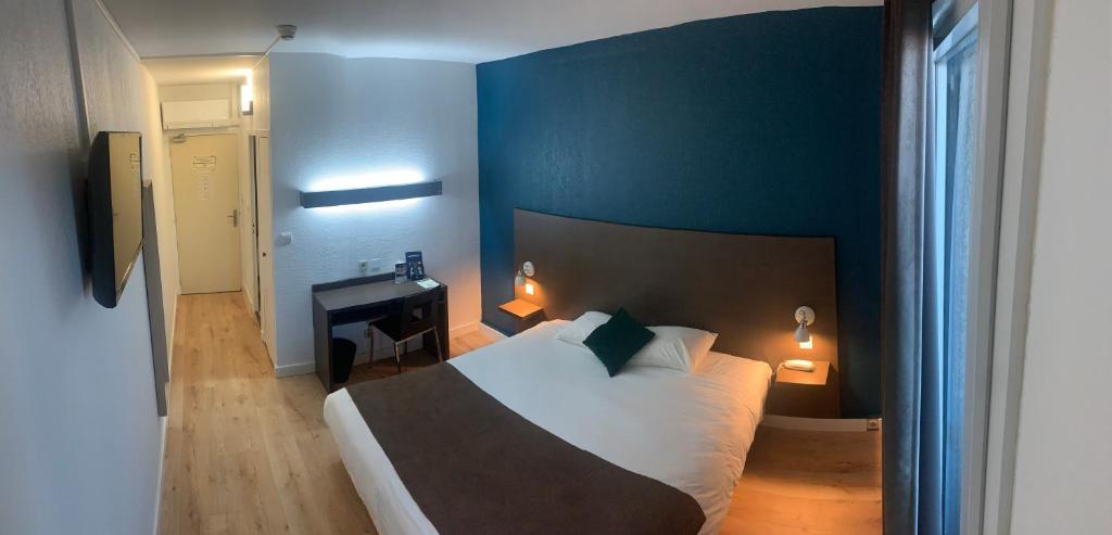 - une chambre avec un lit et un bureau dans l'établissement Hôtel des Etats-Unis, à Toulouse