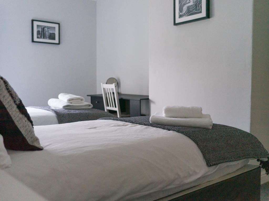 Dos camas en una habitación con toallas. en Chestnut House- 2 Bedroom house in Ashington, Northumberland, en Ashington