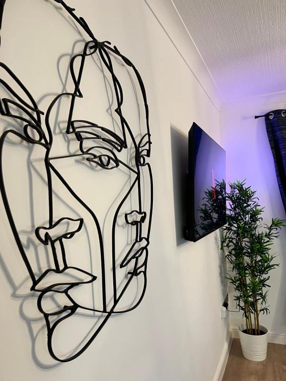 a drawing of a face on a wall at Modern Town-Centre Apartment in Dumfries