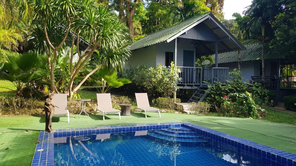 a villa with a swimming pool and a house at COCOON Koh Chang in Ko Chang