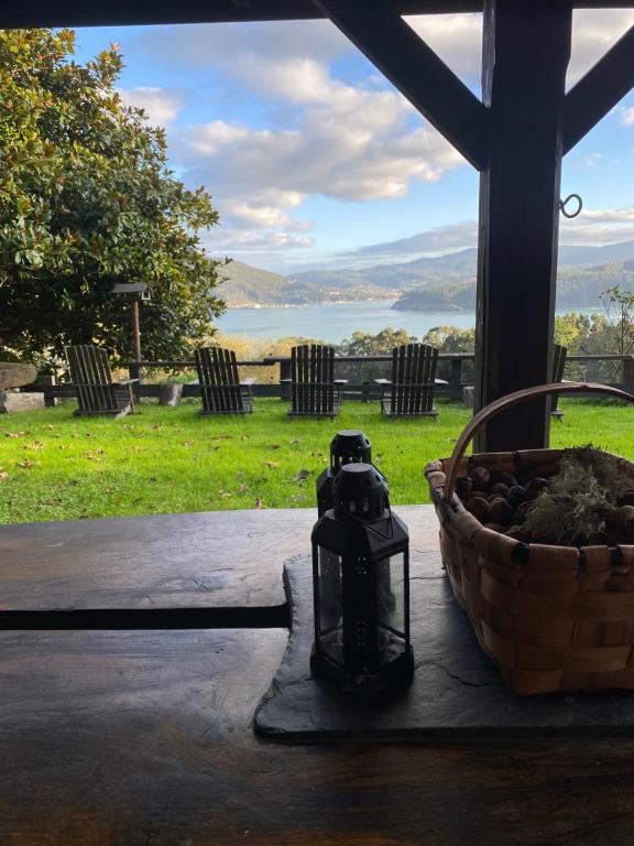 uma lanterna sentada numa mesa com um cesto de pedras em Casa rural Castro de Frádigas, con vistas al mar en Pantín em Valdoviño