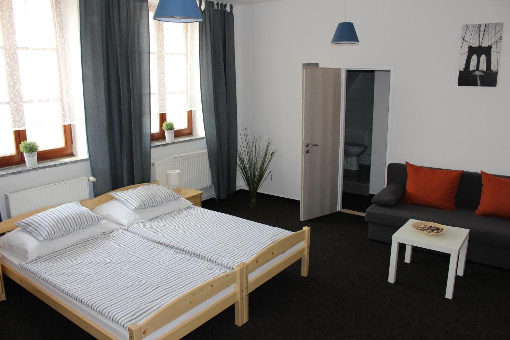 1 dormitorio con 1 cama grande y 1 sofá en Hostinec a Penzion Staré Nádraží, en Ostrava