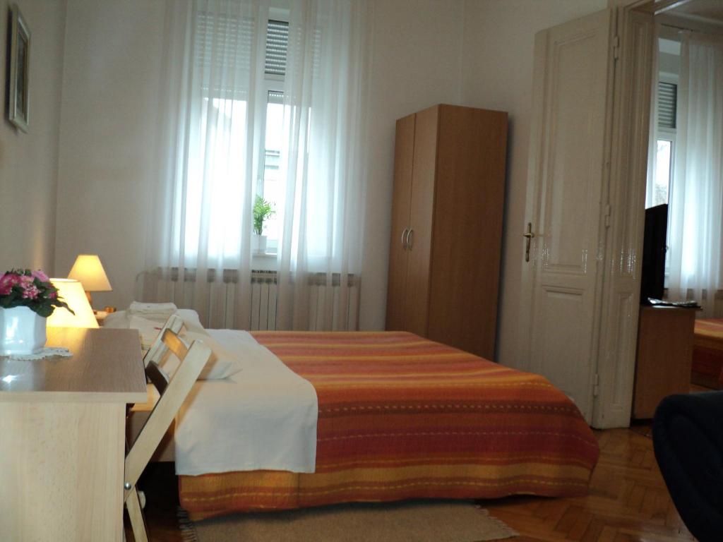 Apartment Horvat في زغرب: غرفة نوم مع سرير وخزانة في غرفة
