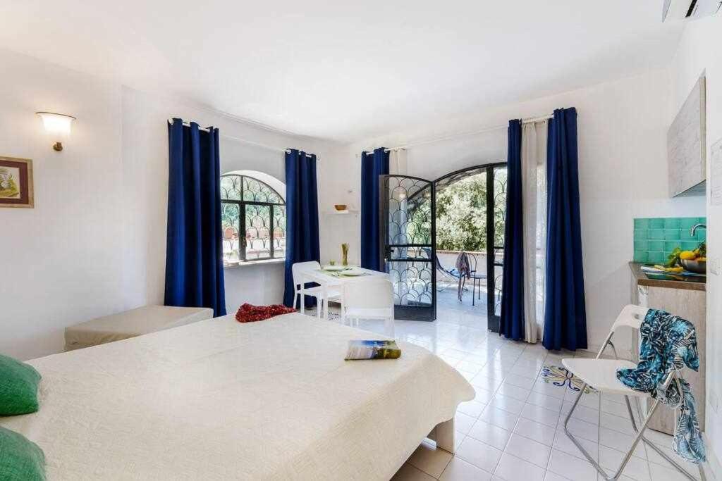 - un salon avec des rideaux bleus et une table dans l'établissement Villa Fratta Rooms peace of mind, à Sorrente