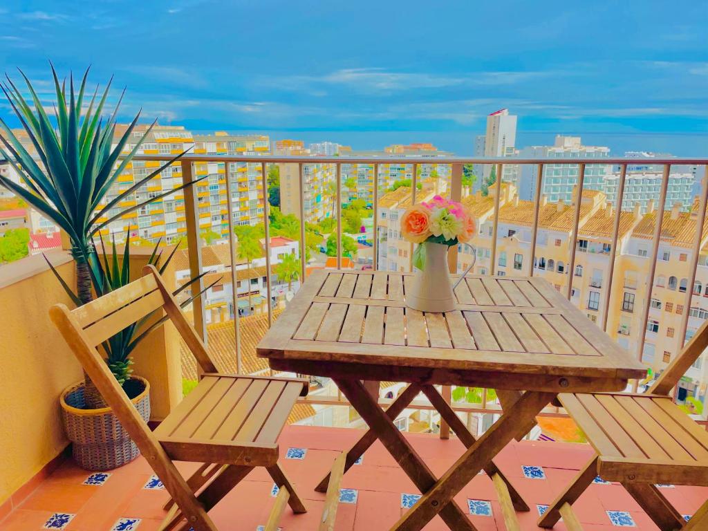 - Balcón con mesa de madera y 2 sillas en LUXURY SUITES MINERVA beach, en Benalmádena