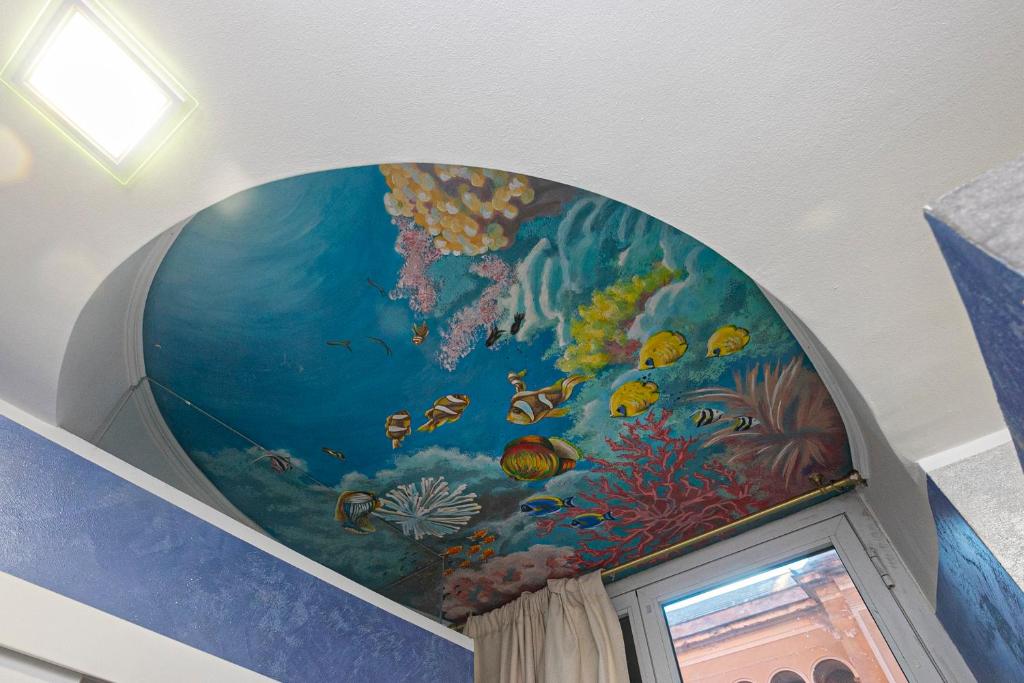 un murale sul soffitto di una camera con acquario di Dimora patrizia in centro a Genova