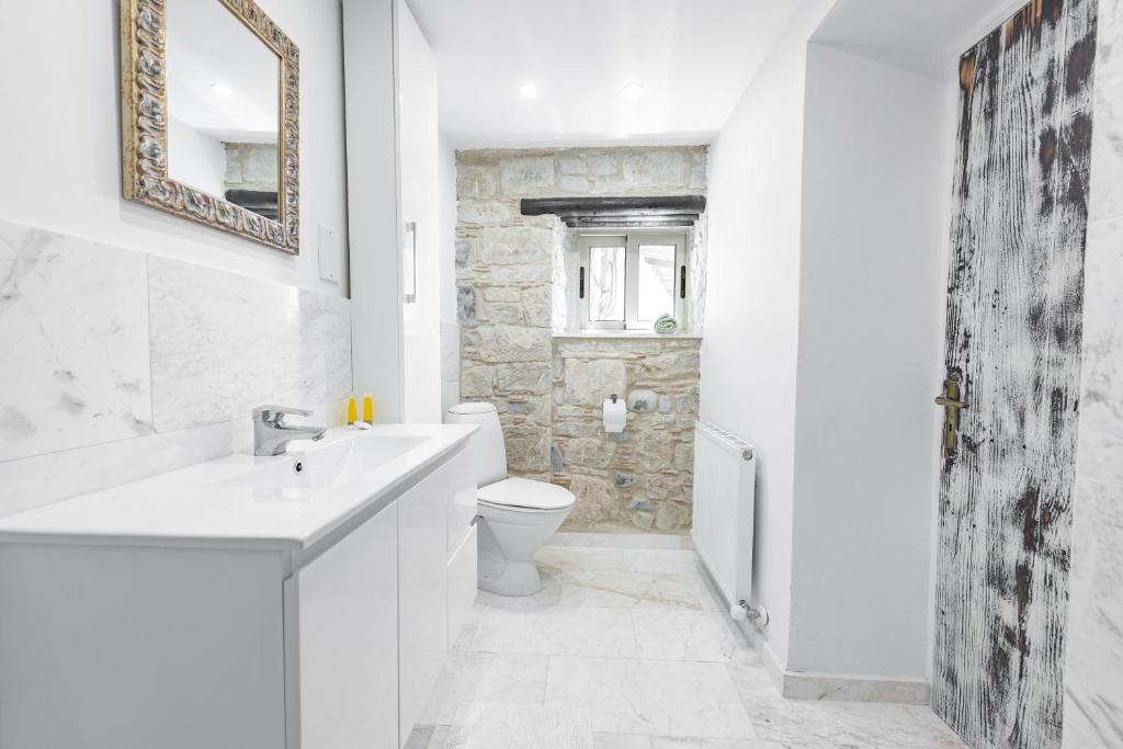 a white bathroom with a sink and a toilet at Cyprus Villages Hotel & Restaurant - Central Location - Bed & Breakfast - With Access To Pool And Stunning Views in Tochni