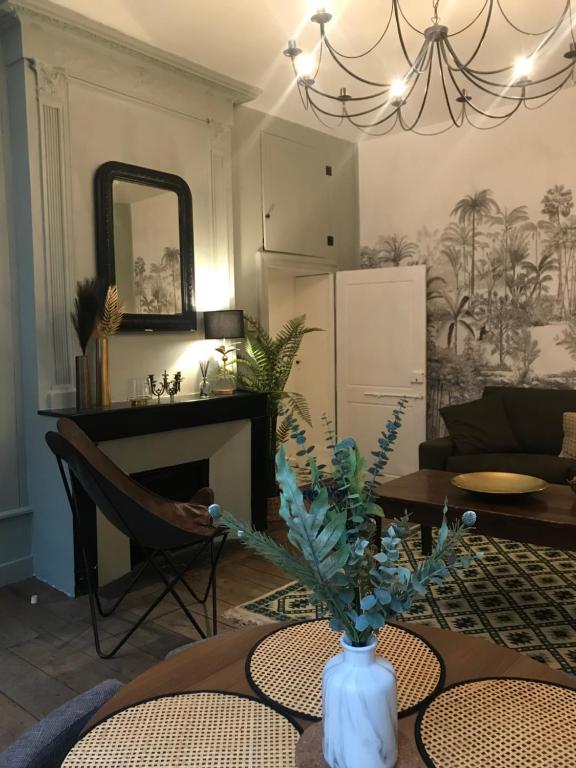 uma sala de estar com uma mesa com um vaso com flores em L'appart 45 em Rodez