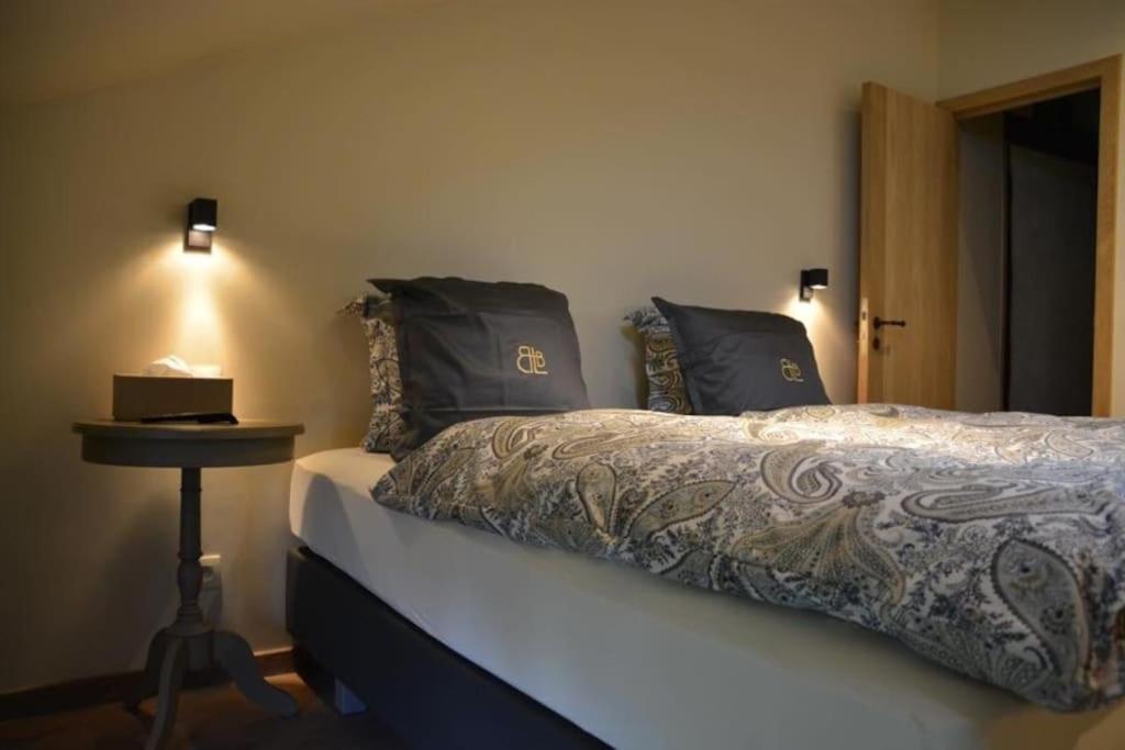 a bedroom with a bed with a night stand next to it at La Légende - Gîte dans un quartier pittoresque in Bouillon