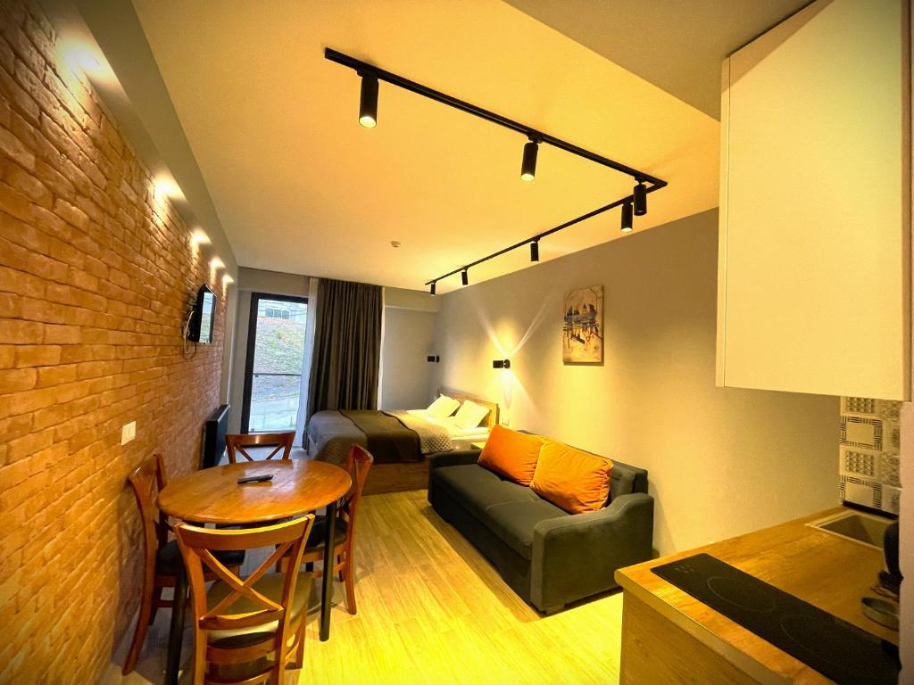 a room with a bed and a table and a couch at SkyWay Twins Studio Gudauri in Gudauri