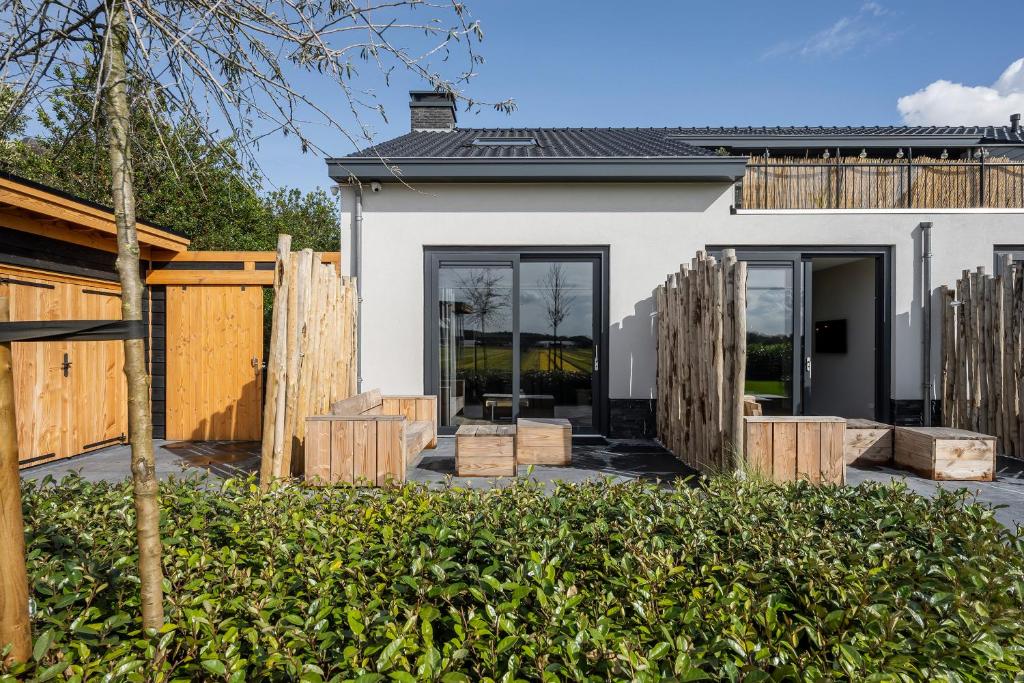 a home with a fence and a house at Holiday Apartment Zee in Noordwijk