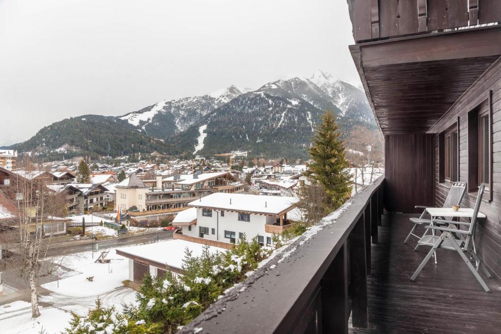 a balcony with a view of a town and mountains at Haus Excelsior Top 21 in Seefeld in Tirol