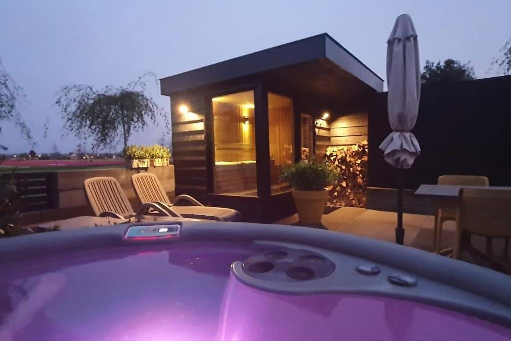 a hot tub in front of a house at Wellness Lodge Ruigenhoek 13A - Sauna, Jacuzzi ! in Zilk