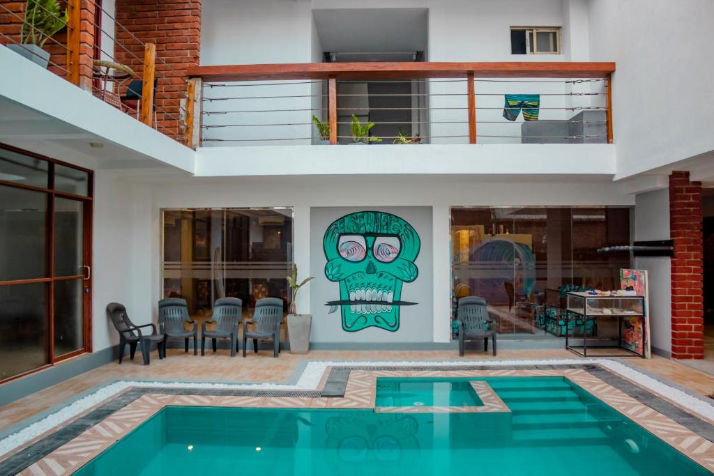 une maison avec une piscine et un tableau sur le mur dans l'établissement Surf & Party Weligama, à Weligama