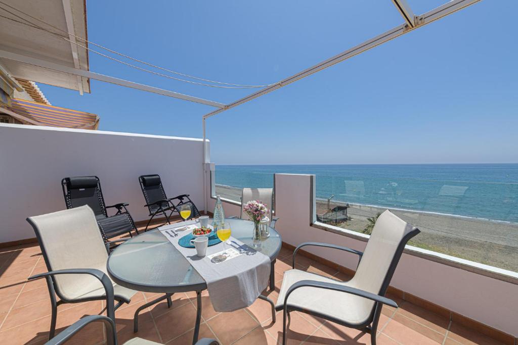 a dining room with a table and chairs and the ocean at WintowinRentals Amazing Front Sea View & Relax in Torre de Benagalbón