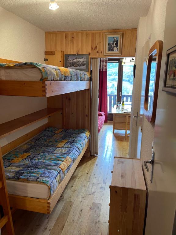 a room with two bunk beds and a desk at Appartement de vacances in Barcelonnette