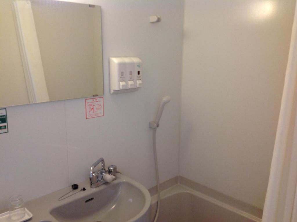a bathroom with a sink and a mirror at Washington R&B Hotel Hachioji in Hachioji