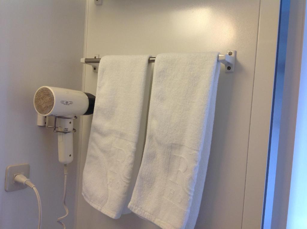a bathroom with white towels hanging on a wall at Washington R&B Hotel Hachioji in Hachioji