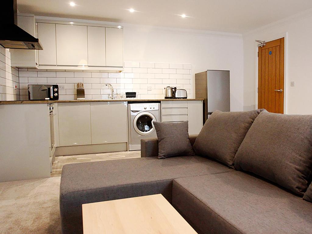 a living room with a couch and a kitchen at The Bridge Apartments in Lowestoft