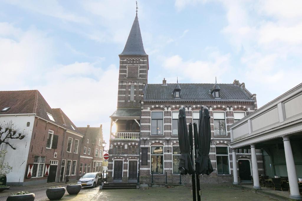 a large building with a tall tower on a street at Edam Suites in Edam