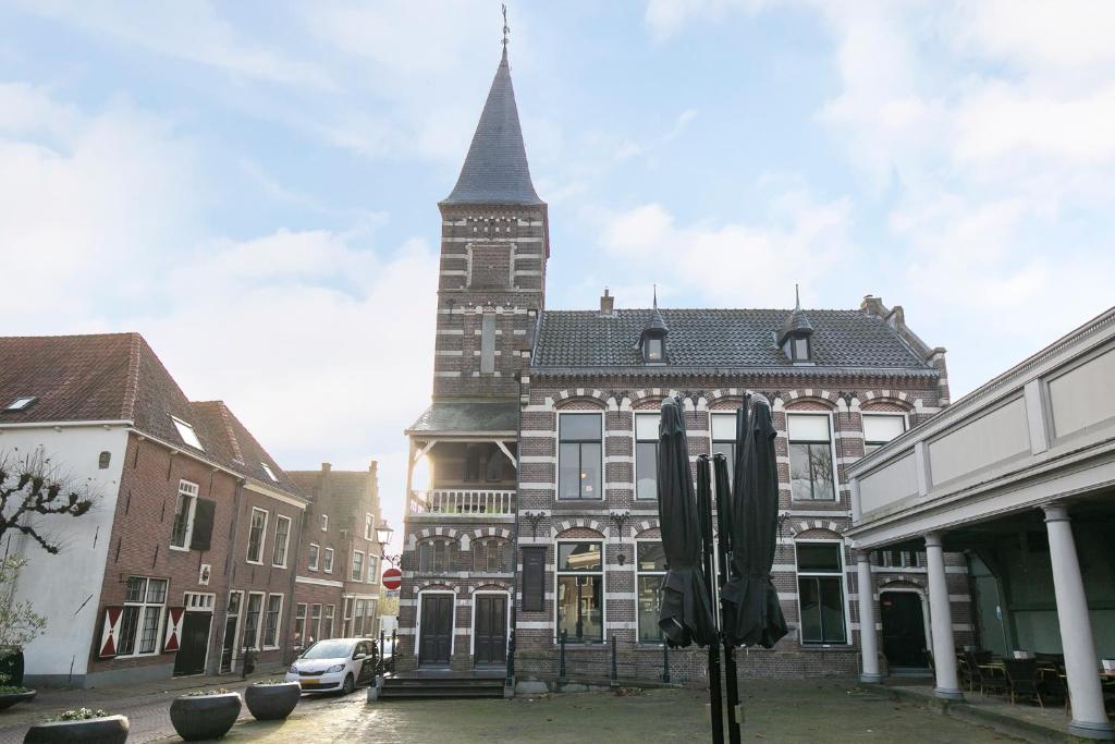 ein großes Gebäude mit einem hohen Turm auf einer Straße in der Unterkunft Edam Suites in Edam