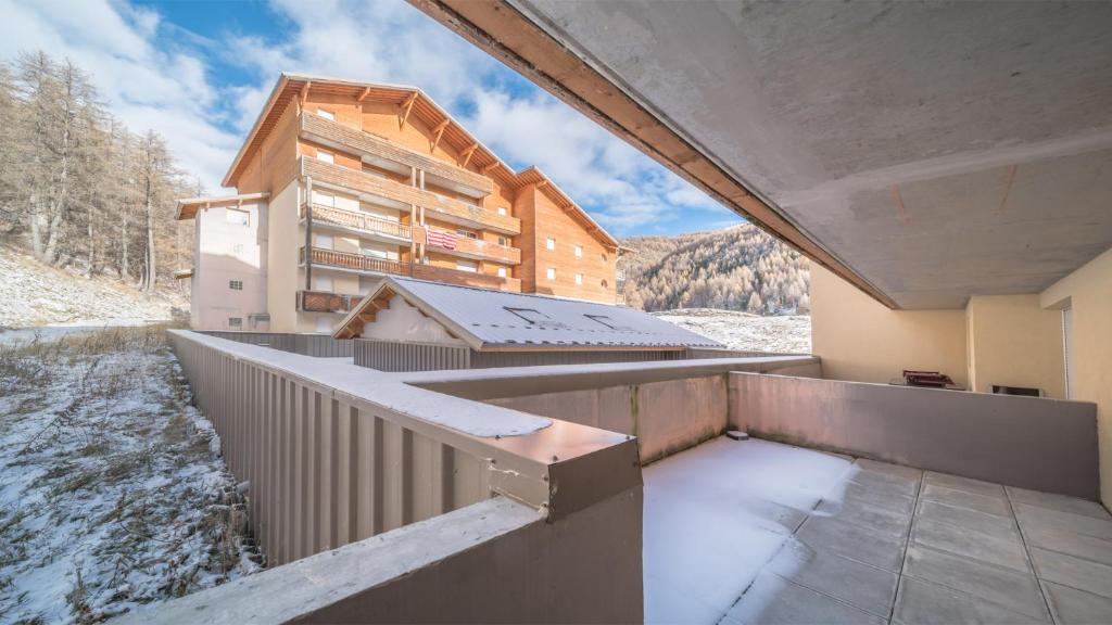 un balcón de un edificio con nieve en el suelo en T de Labrau-2109-Appart ski au pied- 6 pers en Allos
