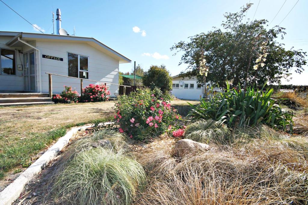 una casa con un cortile con piante e fiori di Ranfurly Holiday Park & Motels a Ranfurly