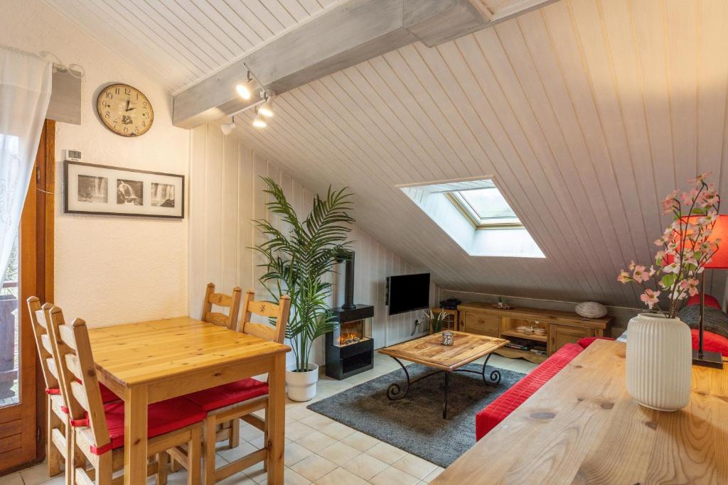 a living room with a table and a dining room at Le Forchat - proche des pistes in Bellevaux