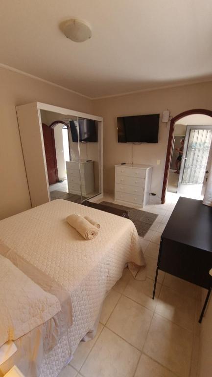 a bedroom with a bed and a desk and a television at Quartos aconchegantes em Sobrado grande no meio do Brooklin in São Paulo