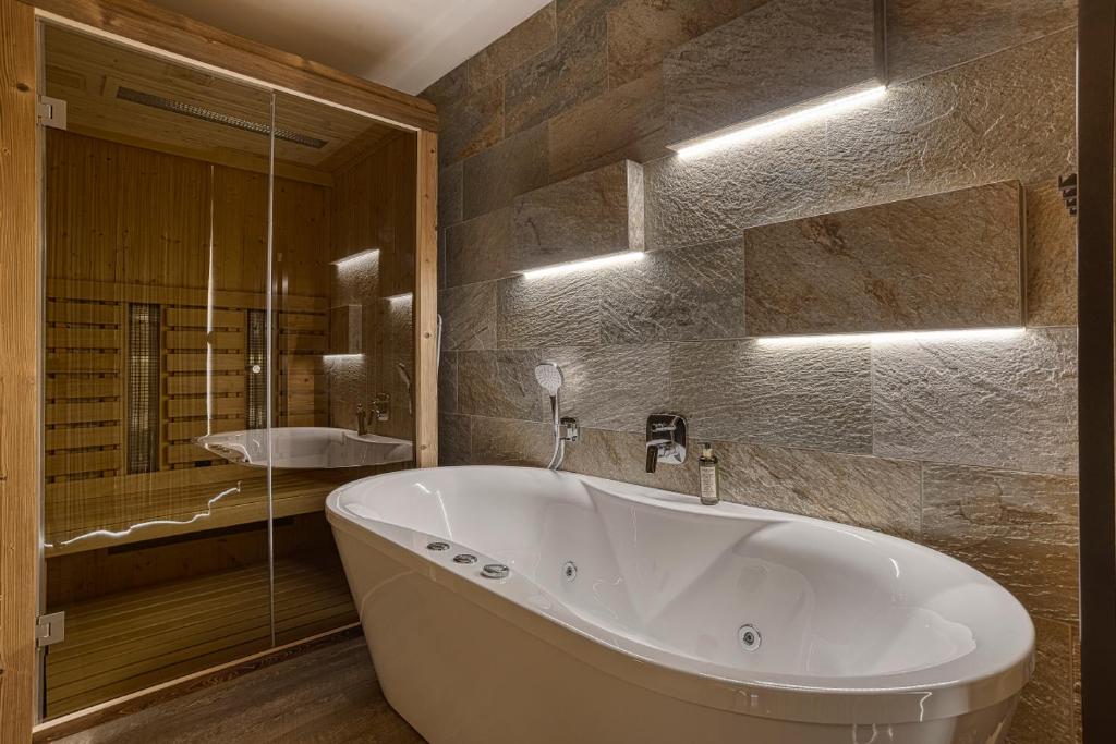 a large white tub in a bathroom with a shower at Apartmán Jelení Grúň Jasná in Belá